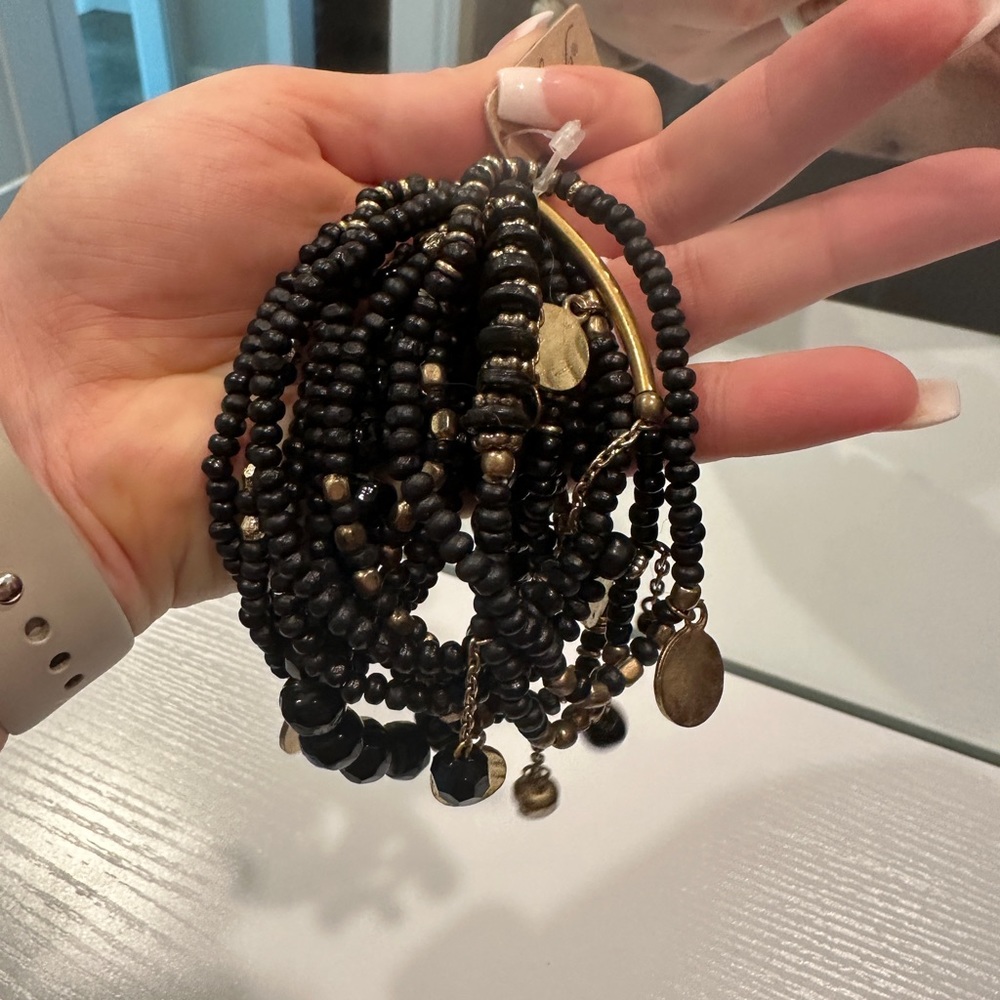 Stack of 10 black and gold stretchy bracelets